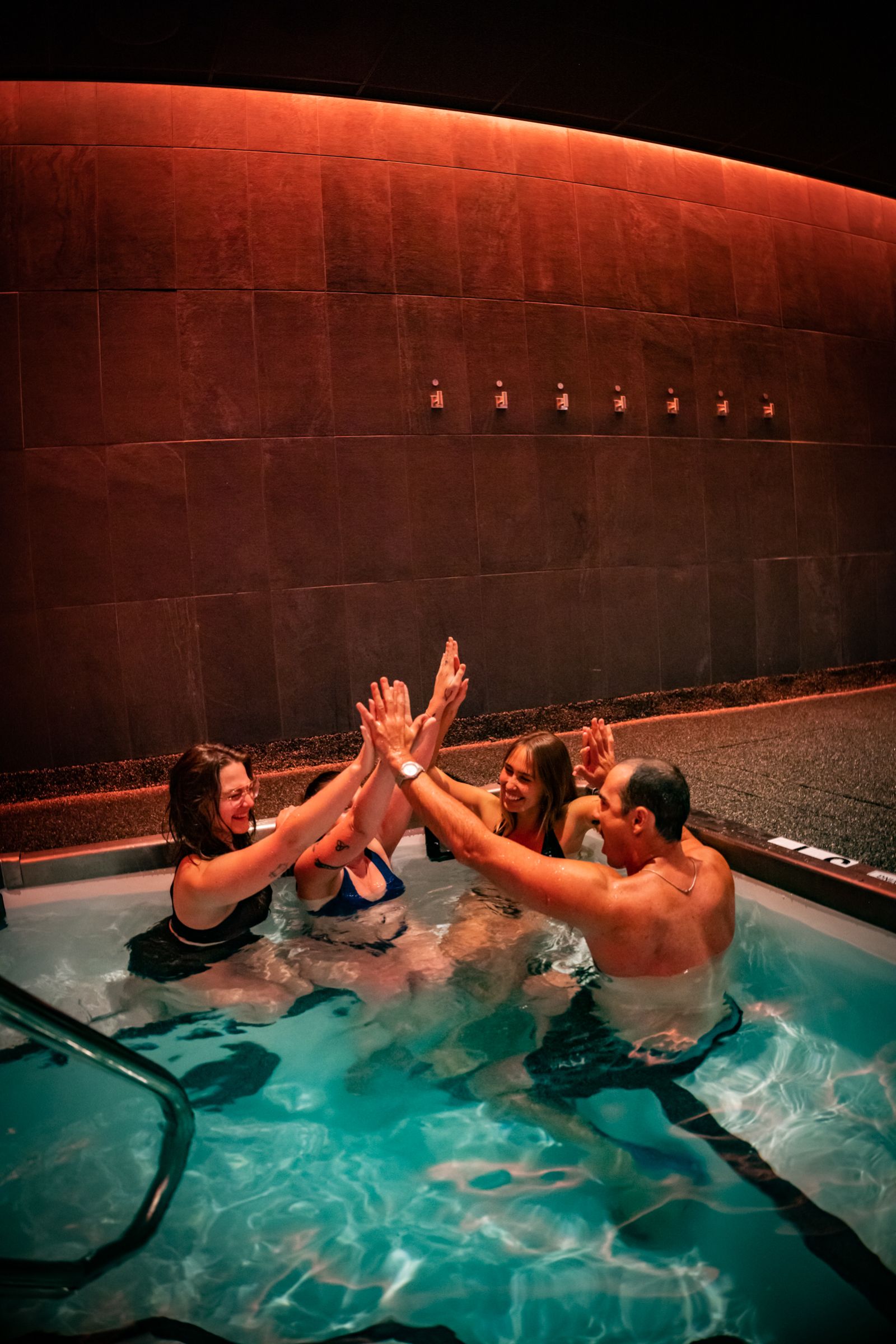 Friends high-fiving in a cold plunge pool at Cellevate wellness spa — social campaign photography, Murrieta and Temecula