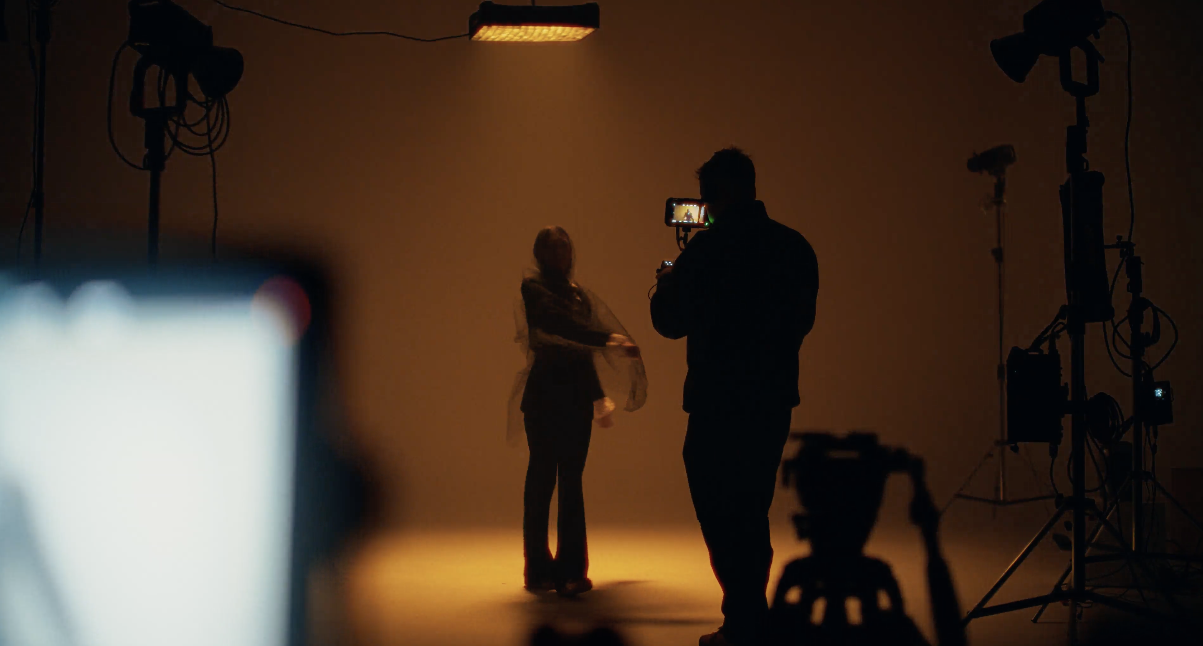 Murrieta Media videographer filming a model under warm studio lighting on a commercial video set — video production for Temecula, California businesses