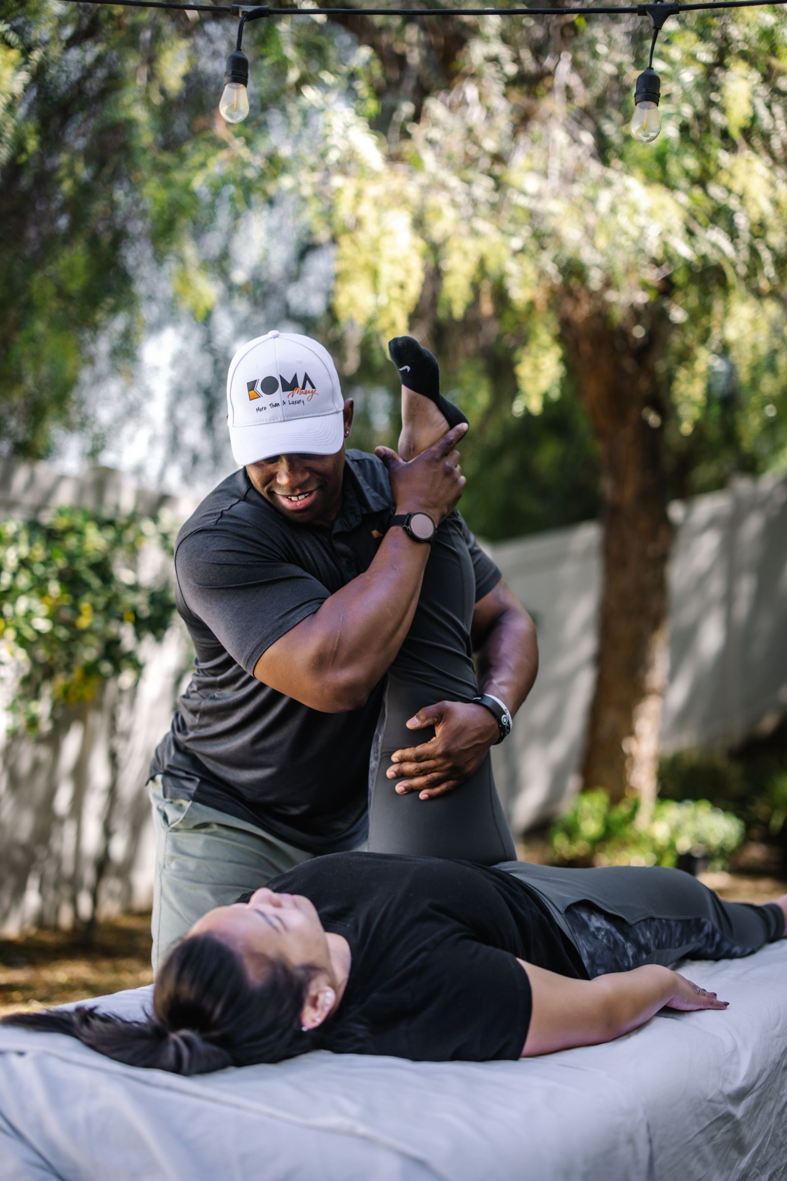 Koma Massage therapist giving an outdoor assisted leg stretch in Temecula Valley — wellness brand photography by Murrieta Media
