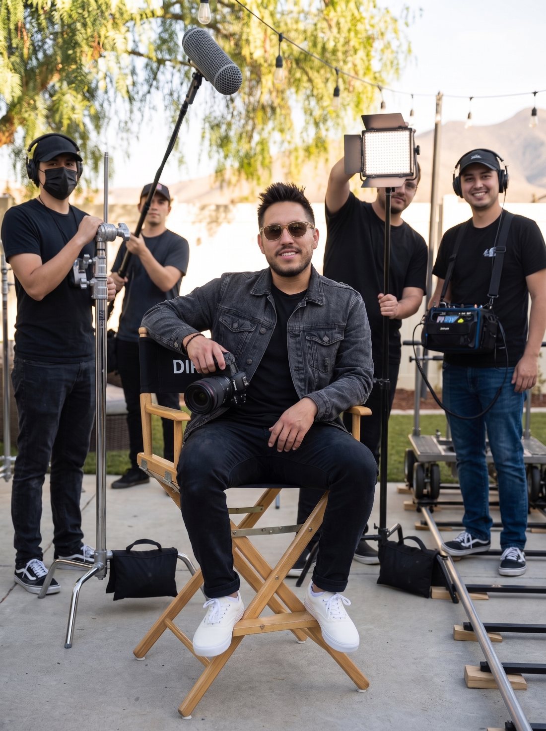 Jonathan Ramirez seated in a director's chair with camera in hand and the Murrieta Media crew on set with boom mic, lights and dolly track — video production team in Murrieta and Temecula, Southern California