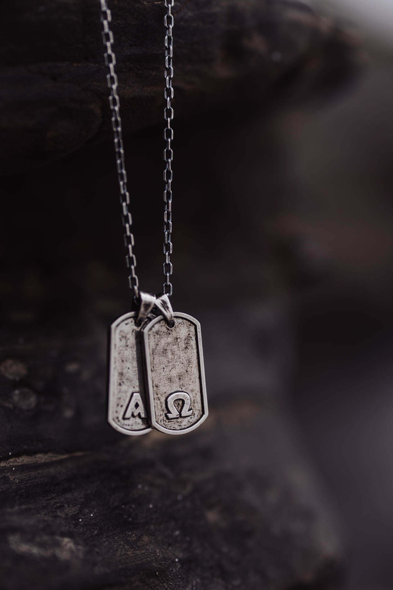 Darma alpha and omega silver dog tag pendants on chain — men's jewelry product photography by Murrieta Media, Murrieta California