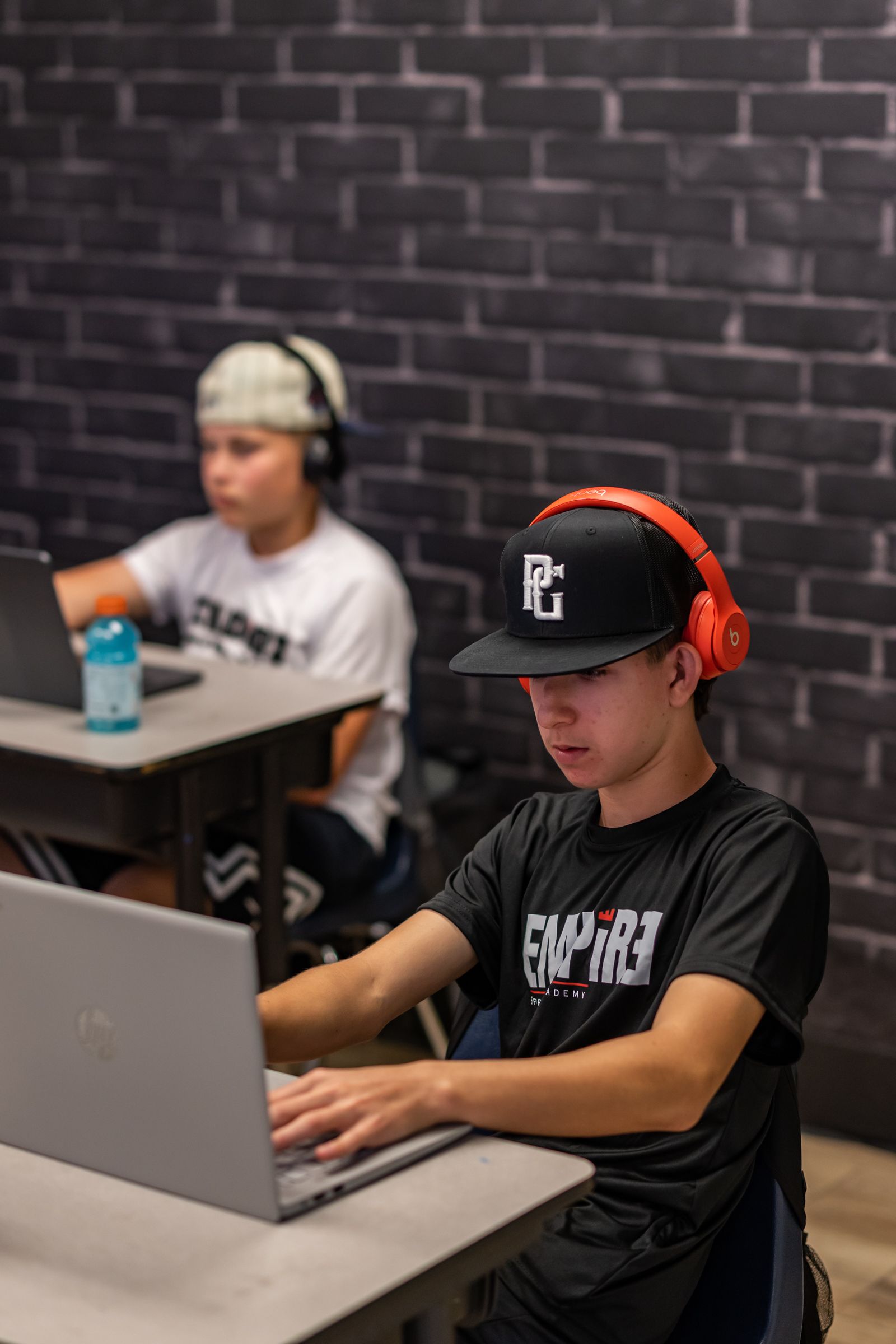 Empire Sports Academy athlete studying on laptop with headphones — student athlete program in Murrieta, media by Murrieta Media