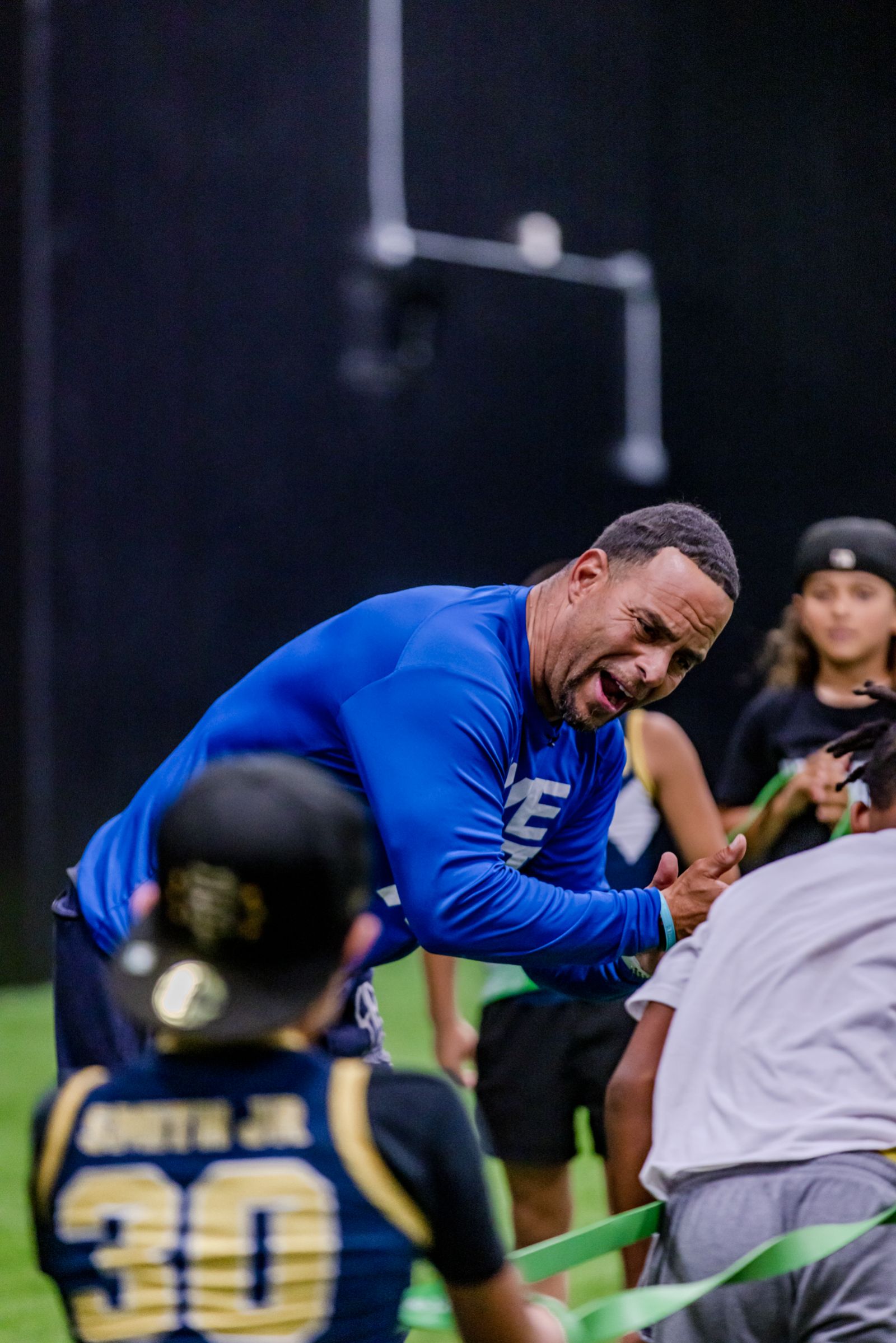 Coach leading flag football drills with young athletes at Empire Sports Academy indoor field in Murrieta — sports videography and photography by Murrieta Media
