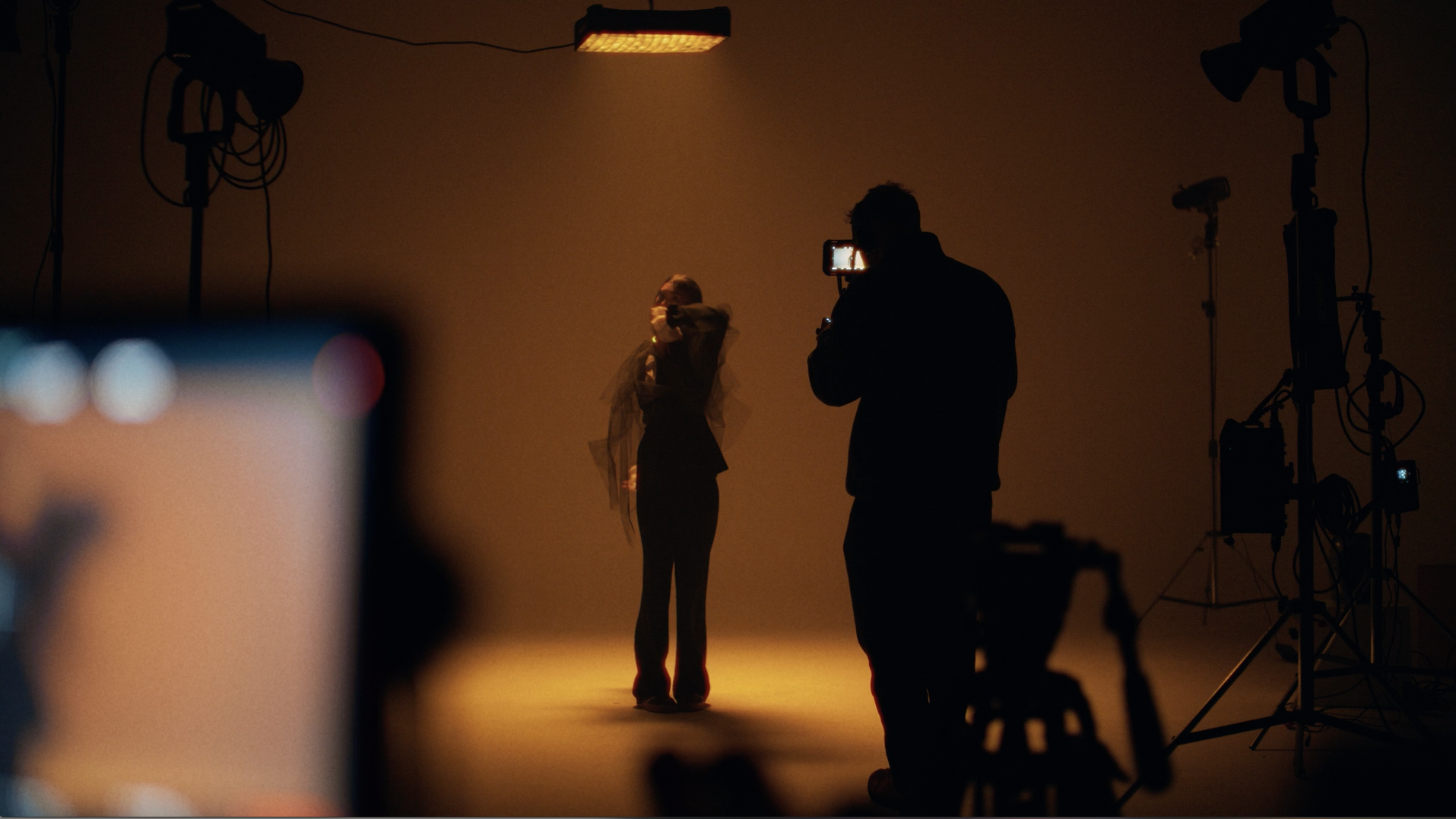 Murrieta Media videographer filming a model under warm studio lighting on a commercial video shoot — cinematic video production for businesses in Murrieta, Temecula and Southern California